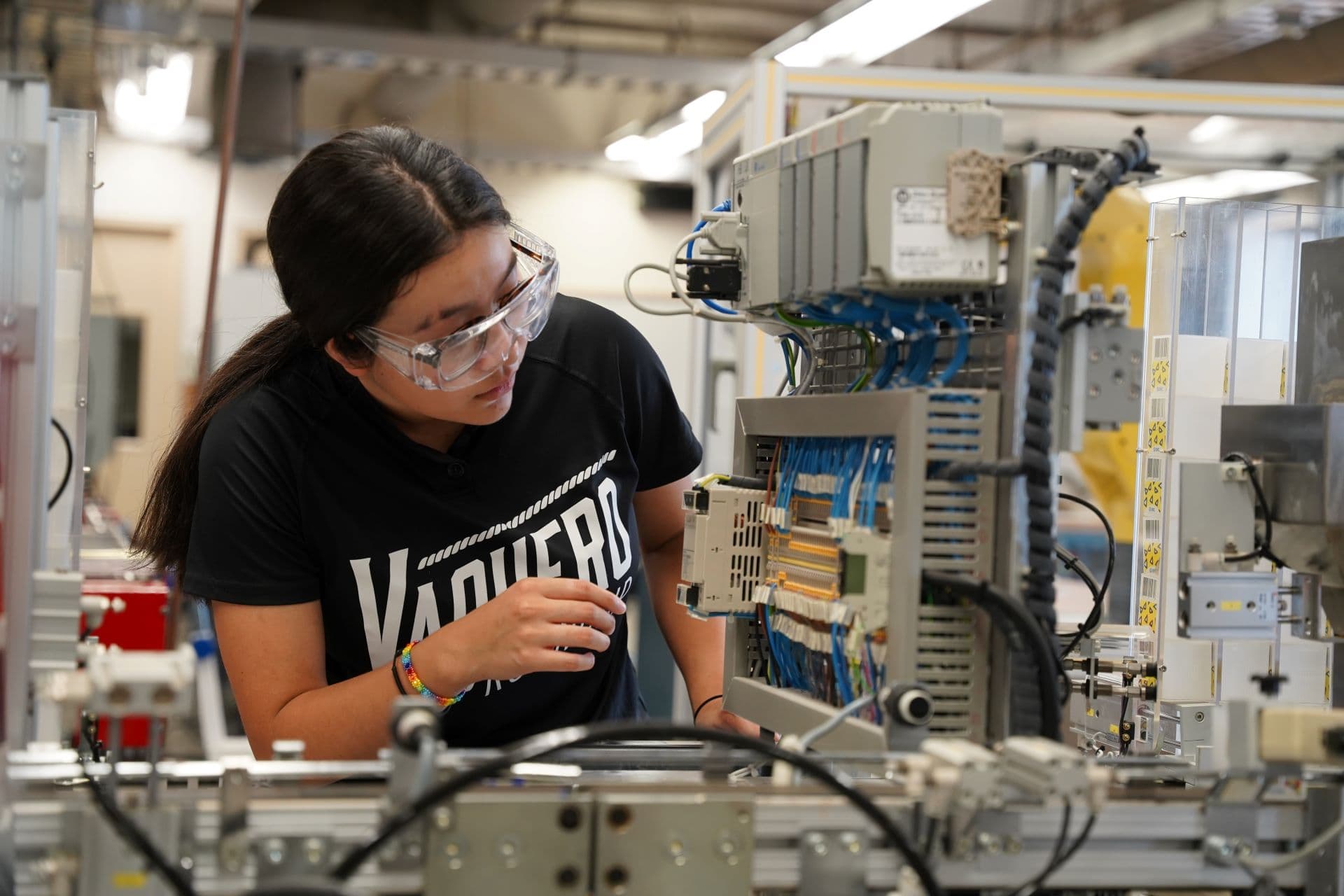 A manufacturing engineering student working with automated equipment