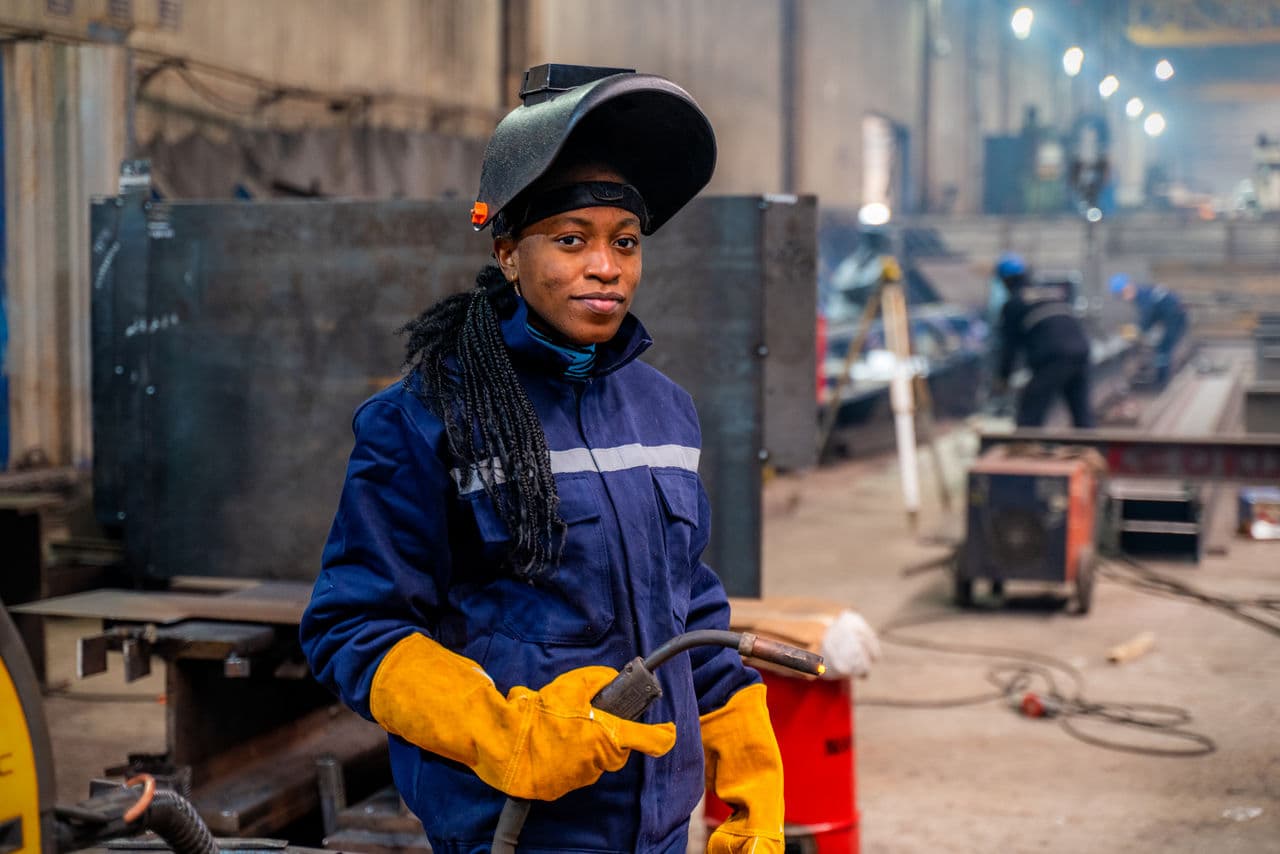 A young welder standing in a fabrication shop